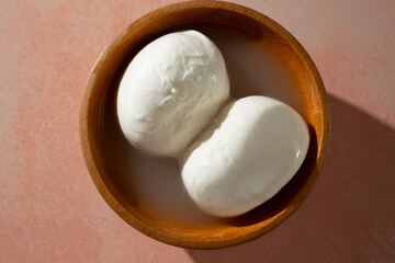 A top down view of burrata in a wood bowl.