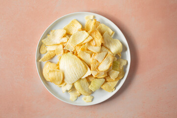 A top down view of a plate of onion chips.