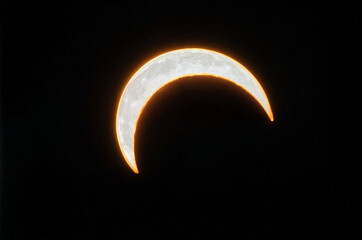 A crescent moon is in the sky with on black background