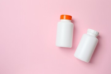 White bottles on color  background, top view