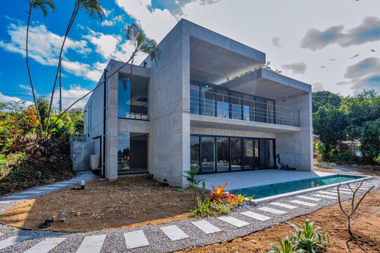 New build modern minimalist house in Okinawa, Japan, constructed of reinforced concrete and glass, with black fixtures and art objects creating a simple but luxurious feel.