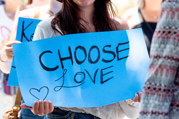A sign at a pride march or rally reads 