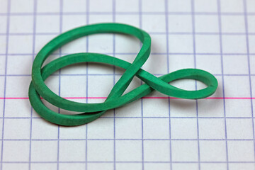 Green rubber band on a sheet of paper