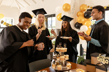 Diverse graduates celebrating with snacks and drinks at home, enjoying their success