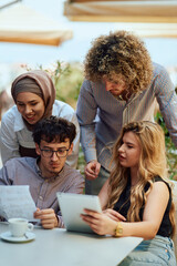 Obraz premium A Diverse MultiEthnic Group Reviewing Projects During a Work Break in a Caffee.