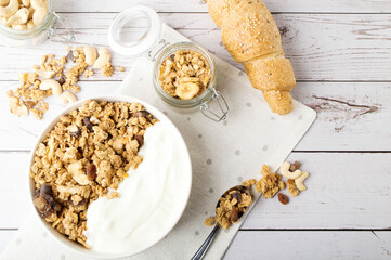 Muesli with nuts, croissant. Oat muesli with almond, cashew, banana. Healthy food, top view