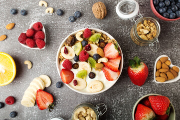 Muesli with organic berries and nuts. Oat muesli with raspberry, blueberry, strawberries, kiwi, almond, cashew, banana. Healthy food, top view