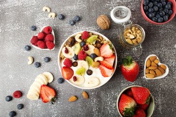 Muesli with organic berries and nuts. Oat muesli with raspberry, blueberry, strawberries, kiwi, almond, cashew, banana. Healthy food, top view