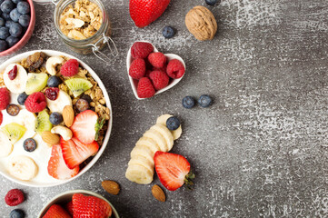 Muesli with organic berries and nuts. Oat muesli with raspberry, blueberry, strawberries, kiwi, almond, cashew, banana. Healthy food, top view
