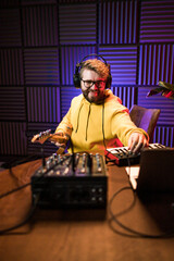 Sound engineer working at mixing panel in the boutique recording studio.