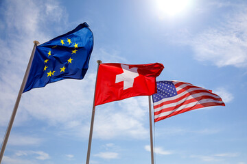 The flags wave in the wind against a blue sky