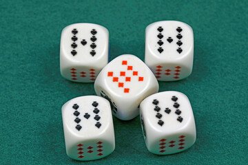 White dice for the game, that have been rolled on a green cloth