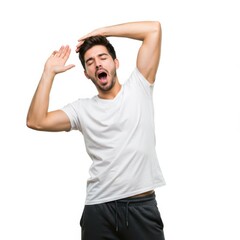 Fototapeta premium A young man in sportswear is yawning and stretching his arms, on a white studio background.