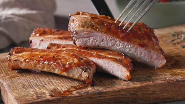 freshly roasted pork ribs on rustic wooden cutting board
