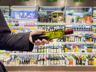 choosing olive oil, sauce, vinegar at the grocery store