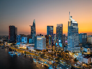 night view of illuminated Ho Chi Minh city skyline and Saigon river, neon street lights of...