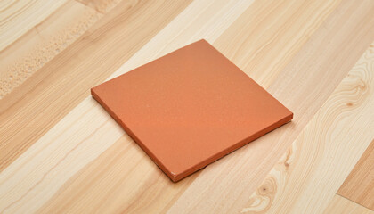 Matte terracotta tile on smooth wooden floor, minimalistic elegance