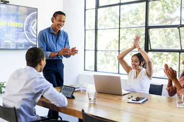 Business diverse team celebrating successful project launch in modern conference room, at office
