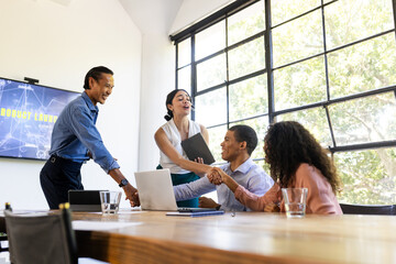 Celebrating successful product launch, diverse business team in modern conference room, at office
