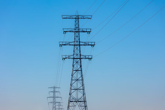 Electric high voltage pole with blue clear sky background, Transmission line pylon lattice tower is a tall structure usually a steel lattice tower, Used to support an overhead power lines, Netherlands