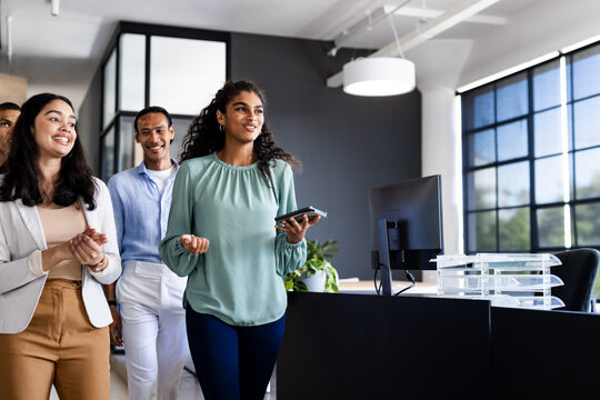Walking through office, diverse business team discussing project with enthusiasm