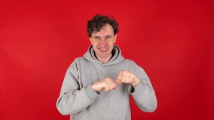 Happy man in casual making dab arms gesture on blank red studio background, funny white guy dabbing moving in internet meme pose celebrating victory having fun, dance school or triumph concept