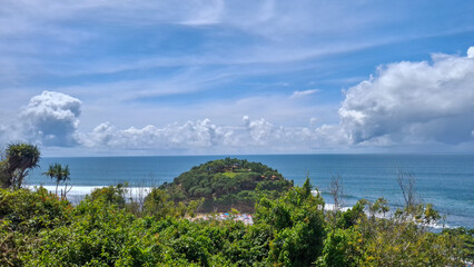 Obraz premium Island View with Lush Greenery and Turquoise Ocean Under Cloudy Sky