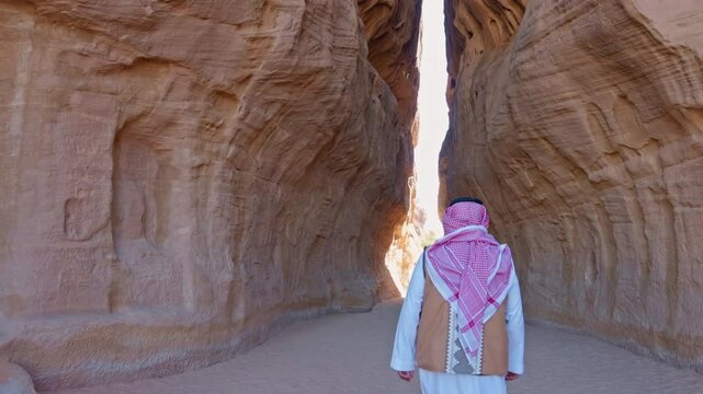 An Arab Saudi man walking at Al-Siq, the narrow passageway known as the al-Siq, runs from al-Diwan (a square chamber that served as a triclinium for sacred feasts), leading to Jabal Ithlib, had decora
