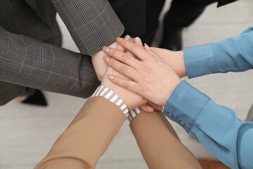 Fototapeta premium Business concept. Group of people stacking hands indoors, above view