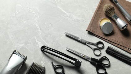 Many different barber's tools on light grey table, flat lay. Space for text