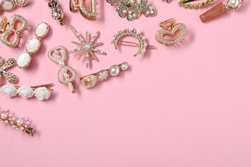 Different hair clips on pink background, flat lay. Space for text