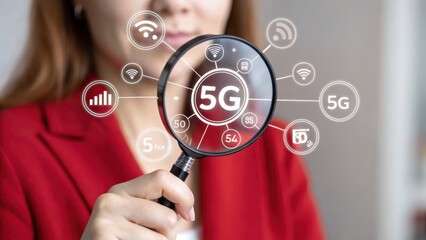5G network. Close up of a woman in a red blazer holding a magnifying glass focusing on a 5G network graphic. The graphic is displayed as a hologram