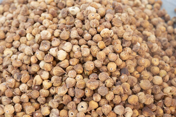 Freshly harvested, dried figs piled high. Their wrinkled texture and earthy brown hues highlight their natural goodness and irresistible appeal.