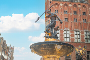 Neptune fountain in the European old town of Gdansk in the center in Poland with the town hall in the background © Sheviakova