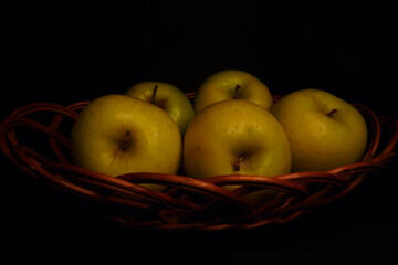 Basket of fruit (apples), taken with a dominance of lateral light that accentuates the shadows in an effect similar to chiaroscuro