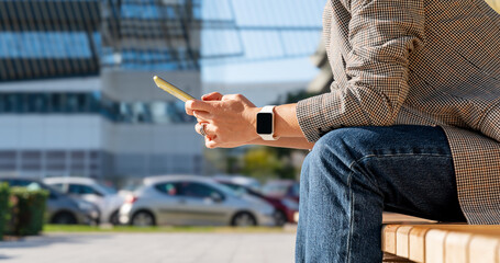 Closeup mobile phone in hands of businesswoman on background of city street  © Barillo_Images