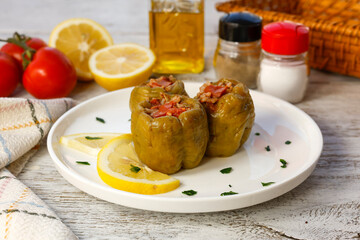 Biber dolma - Biber dolması stuffed peppers on white rustic wood
