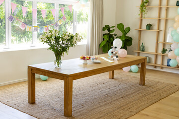 Decorated room with balloons and banner celebrating baby shower, at home