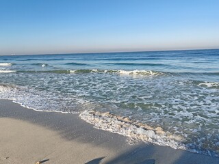 Sea shore and water waves Panorama of a beautiful white sand beach and turquoise water.
Holiday summer beach background, Wave of the sea on the sand beach.
White sandy beach with blue sky as holiday