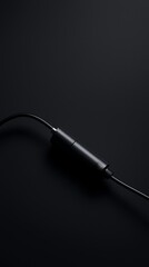 Obraz premium Minimalist black audio cable on dark background.
