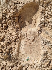 Footstep on sandy area, Foot print on Soil. Footprints in the sand on the beach.
Top view. Sand in the sand pit, shot from above. Footprints of shoes and sandals on brown sand