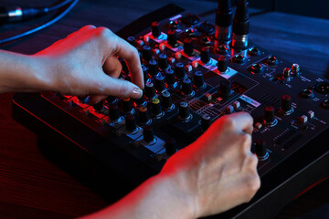 Woman working with professional mixing console at table, closeup
