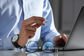Electronic signature. Man with stylus and laptop at white table indoors, closeup