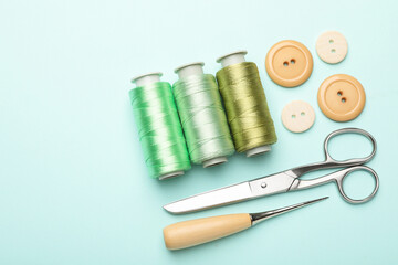 Different sewing supplies on light blue background, flat lay
