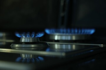 Gas burners with blue flame on stove, closeup