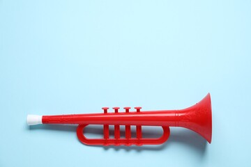 One toy horn on light blue background, top view. Space for text