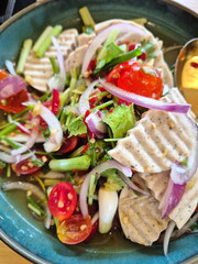 Spicy Vietnamese sausage salad. Pork sausage cut into bite-sized pieces, onions, tomatoes, chilies and spicy seasoning mixed together.  Yum Moo Yor is a popular menu. Top view of colorful spicy food.
