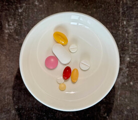 Assorted pills in bowl represent daily pressure care. Pressure control supports heart health, while pressure-focused treatment is essential for managing hypertension. Cardiovascular health concept