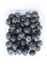 Plastic punnet full of lush blueberries against plain white background