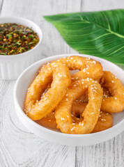 Crispy battered calamari rings with sesame seeds and spicy Asian dipping sauce